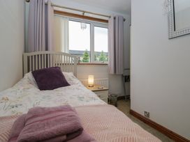 A bedroom with a bed and lamp at Redwood in Ambleside