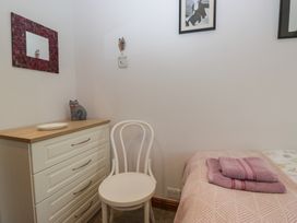 A bedroom with a chair and dresser at Redwood in Ambleside