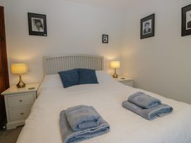 A bedroom with a bed and bedside lamps at Redwood in Ambleside