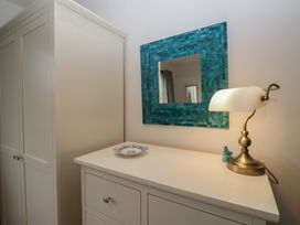 A bedroom with a lamp and mirror at Redwood in Ambleside
