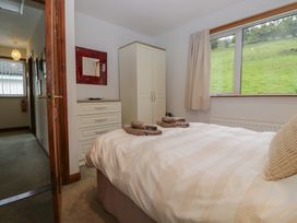 A bedroom with a bed and a dressing table at Redwood in Ambleside