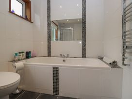 A bathroom with a bathtub and shower enclosure at Redwood in Ambleside