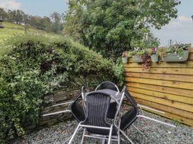 A garden with stacked chairs and planter boxes at Redwood in Ambleside