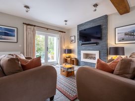 A living room with a television, sofa and coffee table at Goody Raise in Grasmere