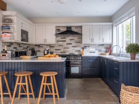 A kitchen with cabinets, oven, sink and stools at Goody Raise in Grasmere
