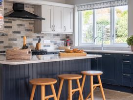 A kitchen with a table and stools at Goody Raise in Grasmere