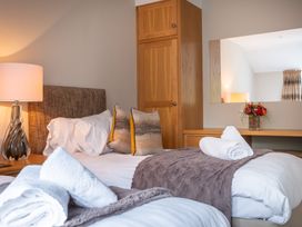 A bedroom with two beds and decorative pillows at Goody Raise in Grasmere