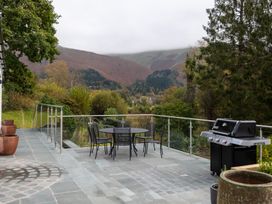 An outdoor patio with a table and chairs and barbecue at Goody Raise in Grasmere