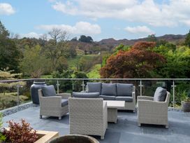 An outdoor patio with seating and a mountain view at Goody Raise in Grasmere