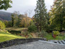 A garden with trees and a stone pathway at Goody Raise in Grasmere