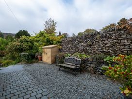 A garden with a bench and a shed at Goody Raise in Grasmere