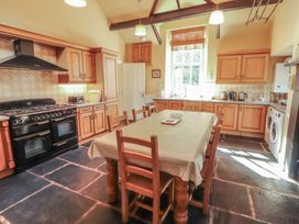 A kitchen with a dining table and appliances at Hawkshead Hall in Hawkshead
