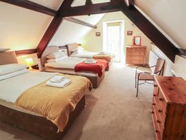 A bedroom with three beds and a dresser at Hawkshead Hall in Hawkshead