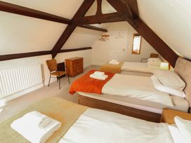 A bedroom with three beds and a chair at Hawkshead Hall in Hawkshead