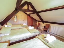 A bedroom with three beds and two chairs at Hawkshead Hall in Hawkshead