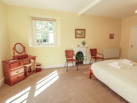 A bedroom with a bed and dresser at Hawkshead Hall in Hawkshead