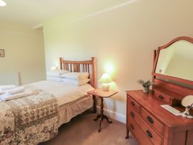 A bedroom with a bed and dresser at Hawkshead Hall in Hawkshead