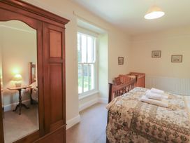 A bedroom with a bed and wardrobe at Hawkshead Hall in Hawkshead