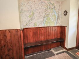 An entrance hallway with a wooden bench and a map on the wall at Rose Cottage Coniston