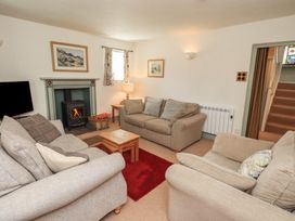 A living room with a fireplace and seating at Rose Cottage Coniston