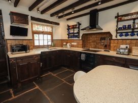 A kitchen with cabinets, sink, stove and appliances at Rose Cottage Coniston