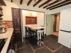 A kitchen with a table and stools at Rose Cottage Coniston in coniston