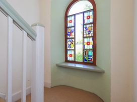 A staircase with stained glass window at Rose Cottage Coniston