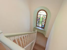 A staircase with a stained glass window at Rose Cottage Coniston