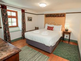 A bedroom with a bed and lamp at Rose Cottage Coniston in coniston