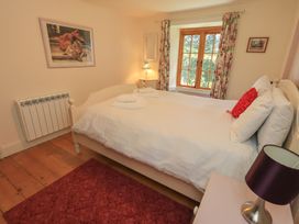 A bedroom with a bed and window at Rose Cottage Coniston in coniston