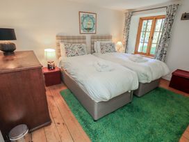 A bedroom with two beds and a window at Rose Cottage Coniston