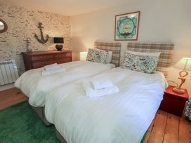 A bedroom with twin beds and wooden furniture at Rose Cottage Coniston in coniston