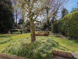 A garden with trees and flowers at Rose Cottage Coniston