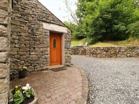 An outdoor entrance with a stone wall and wooden door at Durham Bridge Barn in Crosthwaite