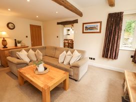 A living room with a sofa and coffee table at Durham Bridge Barn in Crosthwaite