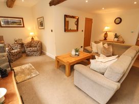A living room with a sofa and armchairs at Durham Bridge Barn in Crosthwaite