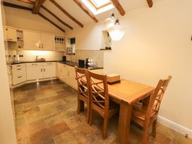 A kitchen with a dining table and chairs at Durham Bridge Barn in Crosthwaite