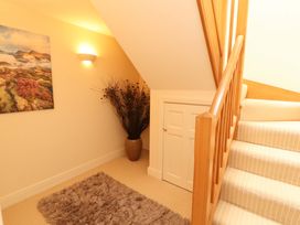 A hallway with stairs and a plant at Durham Bridge Barn in Crosthwaite
