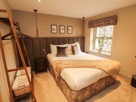 A bedroom with a bed and window at Durham Bridge Barn in Crosthwaite