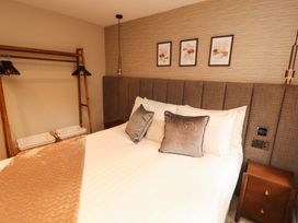 A bedroom with a bed and bedside table at Durham Bridge Barn in Crosthwaite