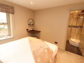 A bedroom with a bed and a shower area at Durham Bridge Barn in Crosthwaite
