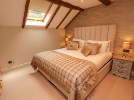 A bedroom with a bed and nightstands at Durham Bridge Barn in Crosthwaite