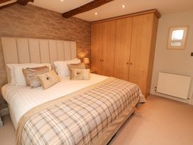 A bedroom with a bed and wardrobe at Durham Bridge Barn in Crosthwaite