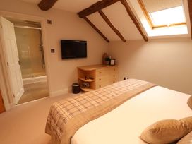 A bedroom with a bed and television at Durham Bridge Barn in Crosthwaite