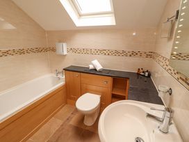 A bathroom with a bathtub, toilet, and sink at Durham Bridge Barn in Crosthwaite