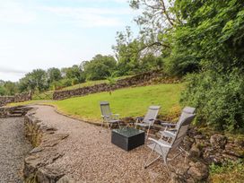 A garden area with chairs and a table at Durham Bridge Barn in Crosthwaite