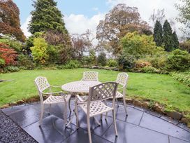 A garden with a table and chairs at Ecclerigg Old Farm Nr. Ambleside