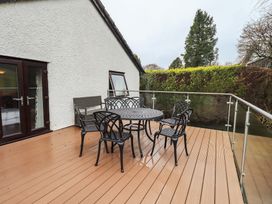 An outdoor deck with table and chairs at Striding Home in Ambleside