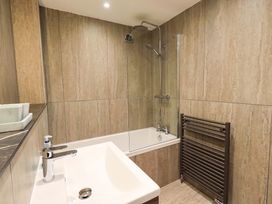 A bathroom with shower over a bath and sink at Gillybeck in Ambleside