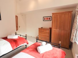 A bedroom with two beds and a wardrobe at Mardale in Ambleside